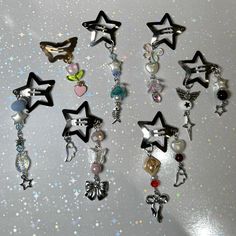 many different types of charms on a white table with glittery stars in the background