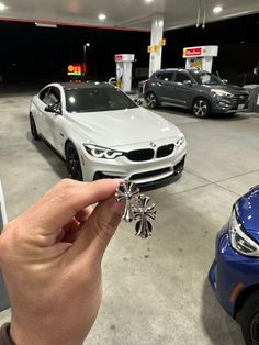 a person holding a key to a car in a parking lot next to other cars