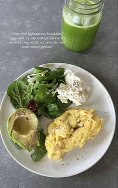 a white plate topped with food next to a green smoothie