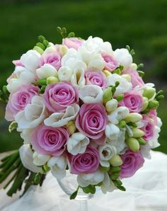 a bouquet of pink and white flowers sitting on top of a table