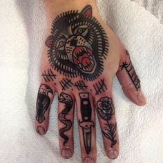 a man's hand with tattoos on it and an animal design on the palm