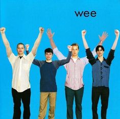 four people standing in front of a blue background holding their hands up with the words wee above them