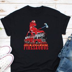 a t - shirt with a fireman on top of a firetruck and flames