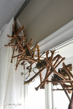 sticks and twigs are hanging from the ceiling in front of a white window sill