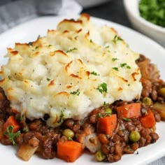 a white plate topped with mashed potatoes and meat