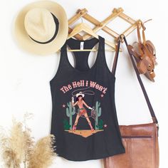 The Hell I Won't Tank Top; SLIM FIT Racerback Tank ★ P R O D U C T * I N F O ★ * all items are made to order ★ P R O D U C T * S P E C S ★ * Women's Ideal Racerback Tank Super Comfy * 3.9 oz., 60/40 combed ring spun cotton/polyester, 30 singles * Fabric laundered * Self-fabric binding * Curved hem * Side seams * Tearaway label --> Slim fit --> Runs smaller than usual --> Please view the size chart photo, in the photos section of the listing. - Colors may differ slightly in person than on a monit Western Style Distressed Cotton Tops, Summer Music Festival Racerback Tank Top, Racerback Tank Top For Summer Music Festival, Country Style Graphic Print Tops For Summer, Fitted Distressed Cotton Tank Top, Distressed Fitted Cotton Tank Top, Black Western Tops For Summer, Black Western Style Tops For Summer, Black Western Style Summer Tops