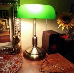 a green lamp sitting on top of a wooden table