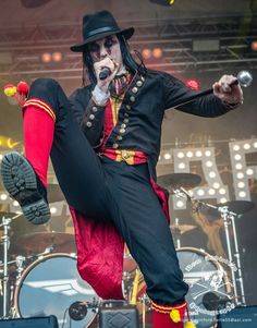 a man dressed in black and red performing on stage