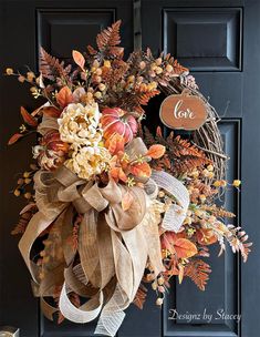 a wreath on the front door decorated with autumn leaves and flowers