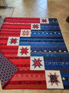 a red, white and blue quilt on the floor