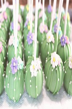 there are many green cake pops with flowers on them