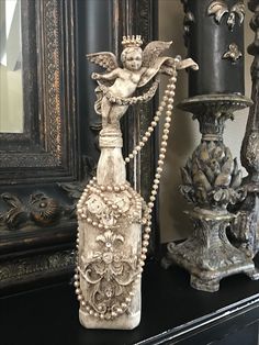 an ornate vase and candle stand on a mantle