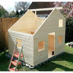 a small wooden house sitting on top of a lush green field