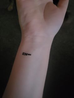 a person's arm with a small wrist tattoo on the left side of their hand