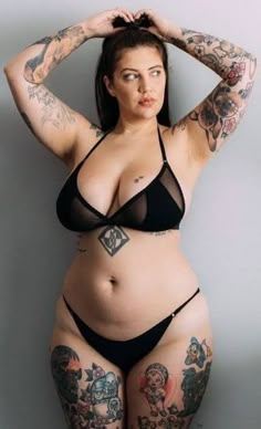 a woman with tattoos on her body posing for the camera