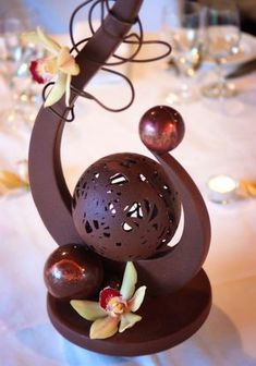 a table topped with a chocolate cake covered in icing and flowers on top of it