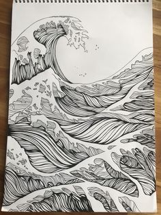 a drawing of an ocean wave in black and white on top of a wooden table