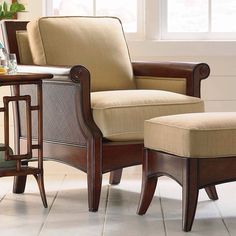 a chair and ottoman in front of a window with white tile on the floor next to it