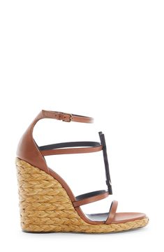 A tonal YSL logo dominates the front of this strappy calfskin sandal given a vacay-ready update with a braided-raffia wedge. 4" (105mm) heel; 1/2" platform (size 37) Adjustable ankle strap with buckle closure Leather/synthetic upper, leather lining and leather/synthetic sole Made in Italy Women's Designer Shoes Luxury T-strap Heels For Summer, Luxury Summer Heels In Calf Leather, Summer Luxury Calf Leather Heels, Luxury Summer Calf Leather Heels, Luxury Calf Leather Heels For Summer, Luxury Brown Sandals With Woven Sole, Luxury Vacation Heels With Heel Strap, Luxury Heels With Heel Strap For Vacation, Luxury Leather Wedge Sandals With Wrapped Heel