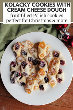 a white plate topped with cookies covered in powdered sugar and cranberry toppings