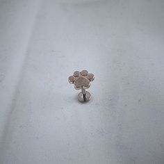 a small dog paw pin sitting on top of a white cloth covered tablecloth,