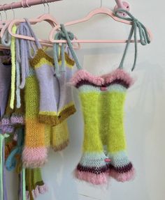 several knitted clothing hanging on a clothes rack