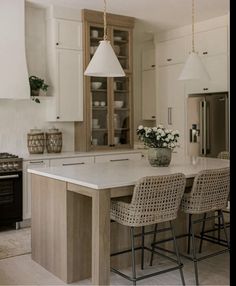 a kitchen with an island and chairs in it