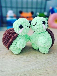 two small stuffed animals sitting on top of a wooden table