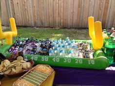 an inflatable table filled with drinks and snacks for a sports themed birthday party