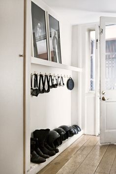 there is a coat rack in the hallway with shoes hanging from it's hooks