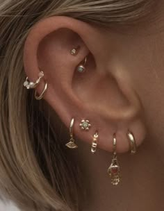 a close up of a person's ear with different types of piercings on it