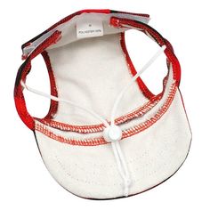 a red and white baseball cap with two strings attached to the visor, on a white background