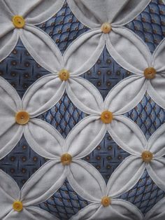 a close up view of a quilted material with buttons on the center and sides