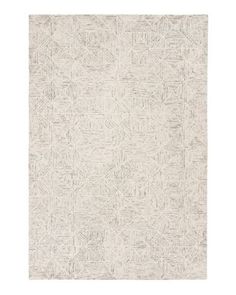 a white rug with an intricate design on the front and back side, in grey tones