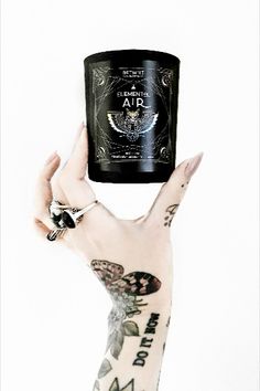 a person with tattoos holding up a jar