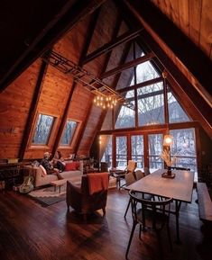 a living room filled with lots of furniture and wooden walls next to a large window