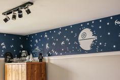 a bedroom decorated in blue and white with star wars wallpaper