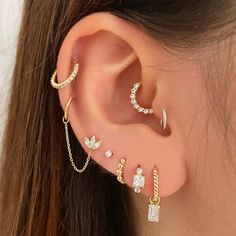 a woman's ear with three different types of piercings