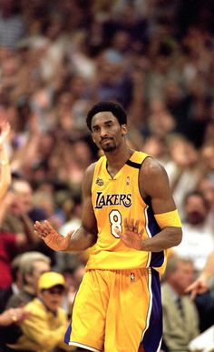 a basketball player standing on the court with his hands in the air and people watching