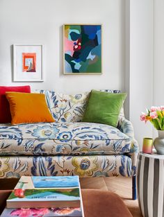 a living room filled with lots of furniture and colorful pillows on top of the couch