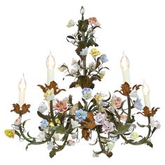 a chandelier with flowers and candles hanging from it's center, on a white background