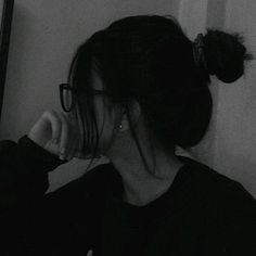 black and white photograph of a woman with her hair in a bun, wearing glasses