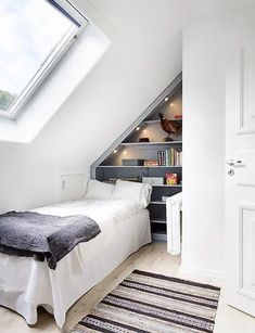 an attic bedroom with slanted ceiling and white walls