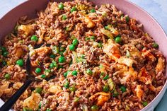 a bowl filled with rice and peas on top of a blue table cloth next to a black spoon