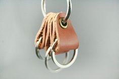 a close up of a keychain with rings on it's end and a leather bag hanging from the front