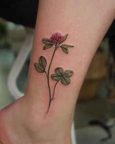 a pink flower with leaves on the ankle