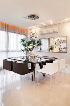 a dining room table with chairs and a chandelier hanging from the ceiling above it