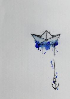 an origami boat floating in the water with blue paint splattered on it