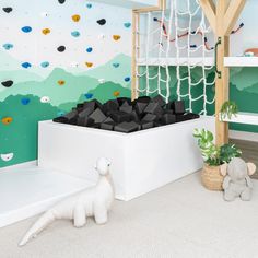 a child's room with climbing wallpaper and black blocks in the play area