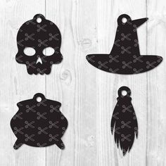 three black and white paper cutouts with skulls on them, one in the shape of a witch's hat